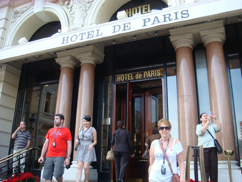 Pam moves past the Ferrari and the Bentley to stand in front of the Hotel De Paris. Monaco.  2011