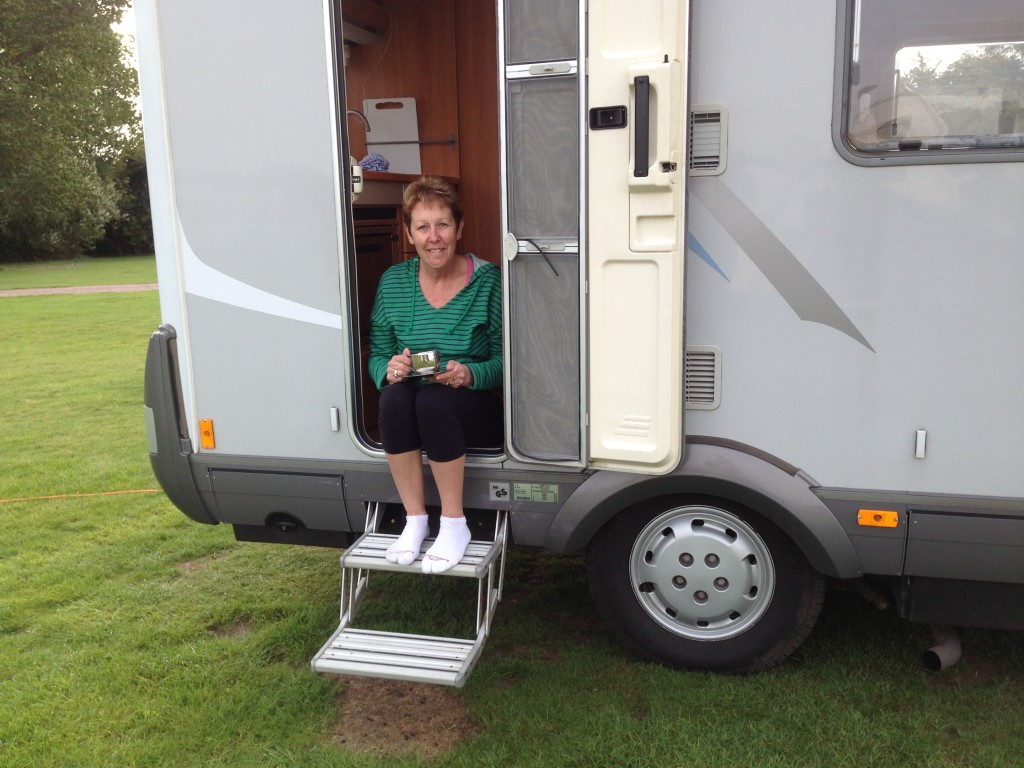 Pam enjoys a morning coffee on the step of our Hymer, Cambridge, UK.  2013